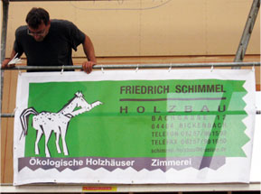 Portrait Friedrich Schimmel mit dem Firmen Banner